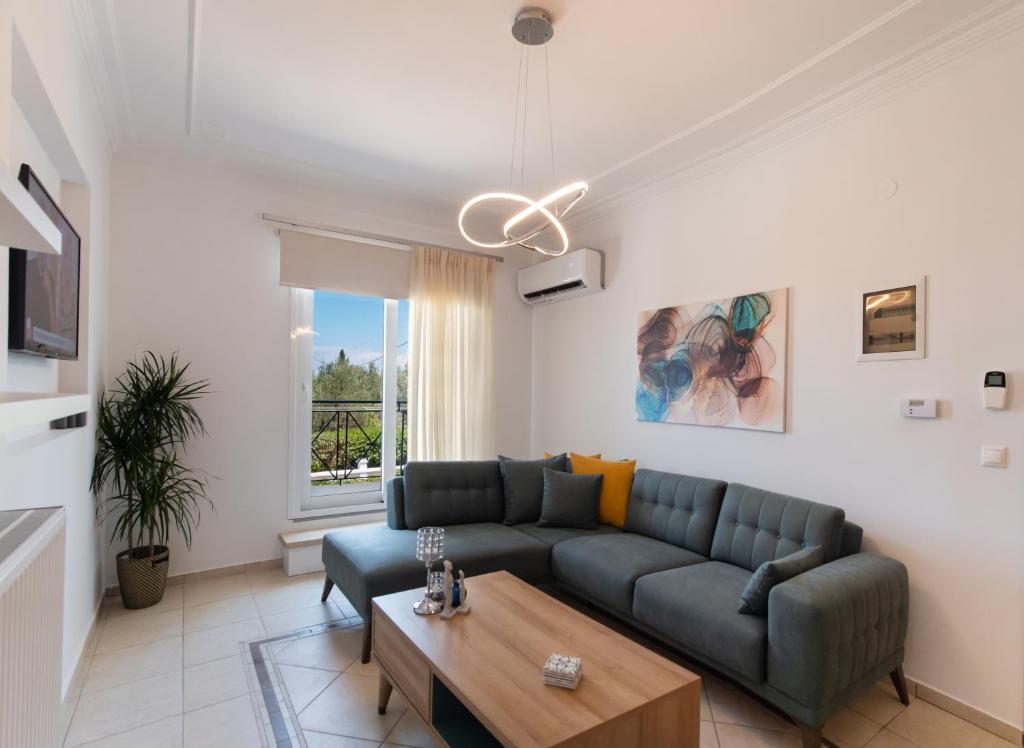 un soggiorno con divano e tavolo di Memoria Apartments by Imagine Lefkada a Città di Lefkada