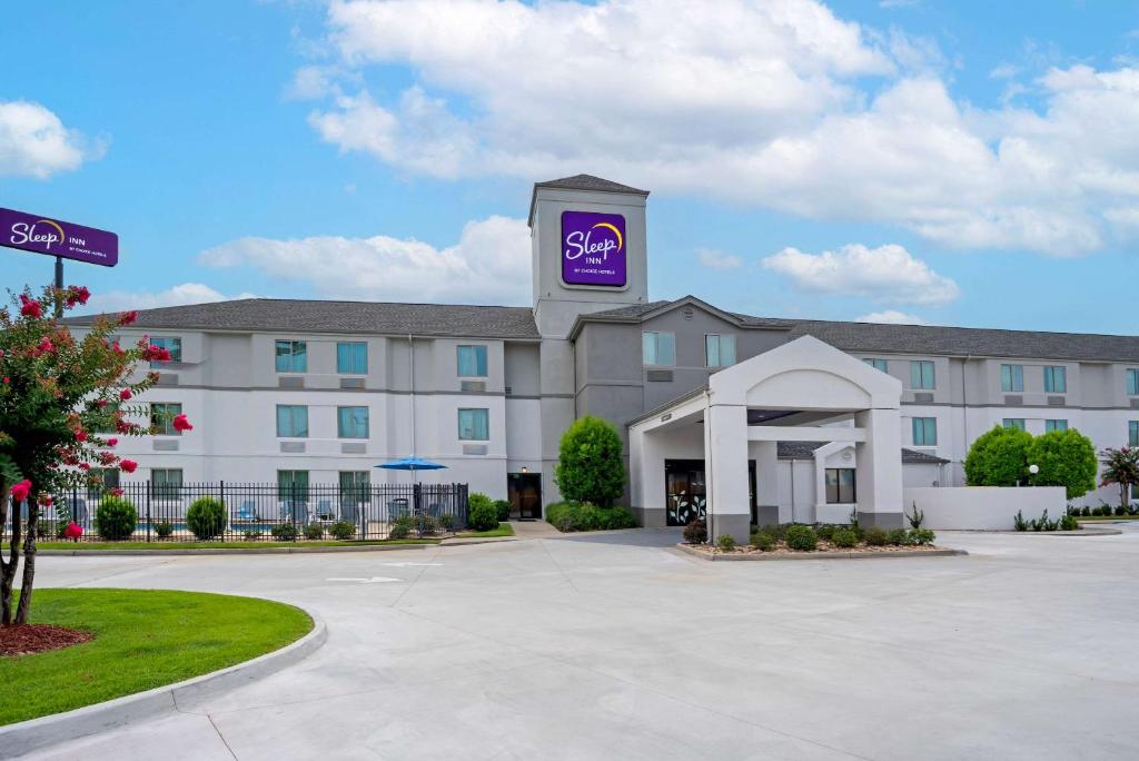 a hotel with a purple sign on the front of it at Sleep Inn Baton Rouge East I-12 in Baton Rouge