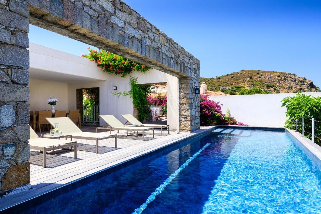 uma villa com uma piscina e um pátio em VILLA CALA ROSSA em LʼÎle-Rousse