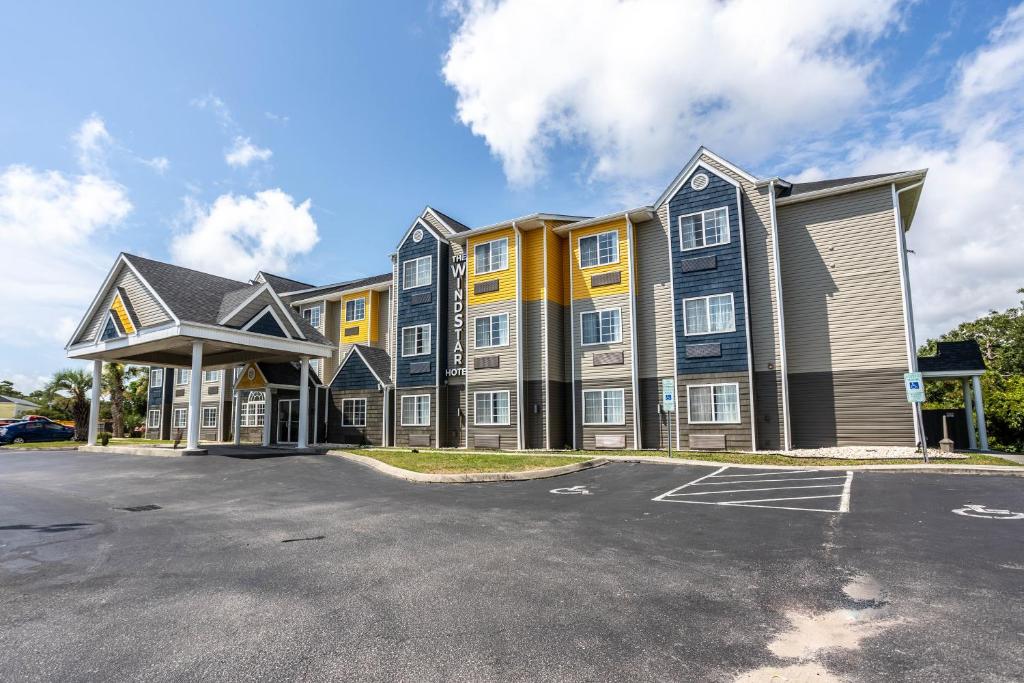 a large apartment building with a parking lot at The Windstar Hotel - Carolina Beach in Carolina Beach