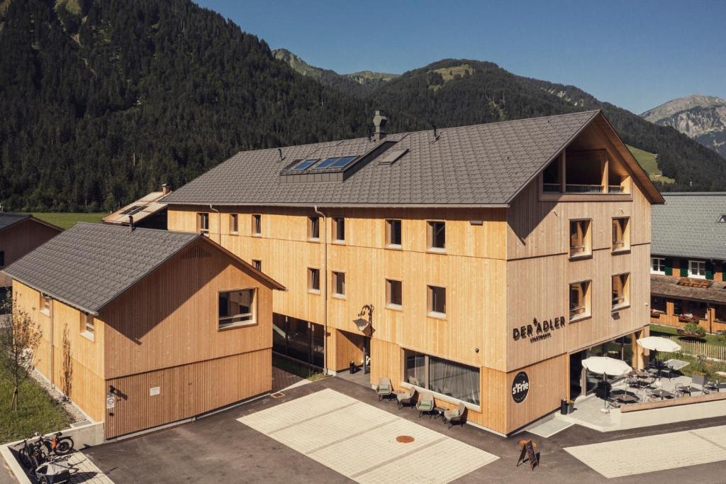 an aerial view of a building with mountains in the background at DER*ADLER Apartments in Schoppernau