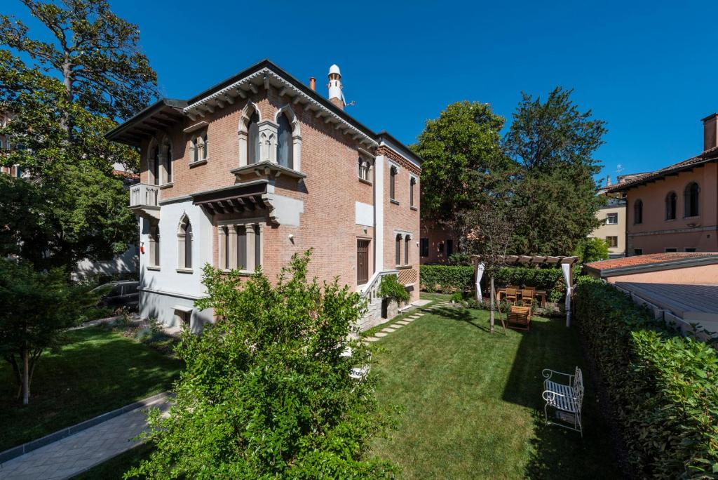 une grande maison en briques avec une cour devant elle dans l'établissement Villa Gallo 1915, sur le Lido de Venise