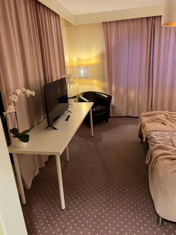 a hotel room with a desk and a bed and a chair at Noah Longstay in Västerås