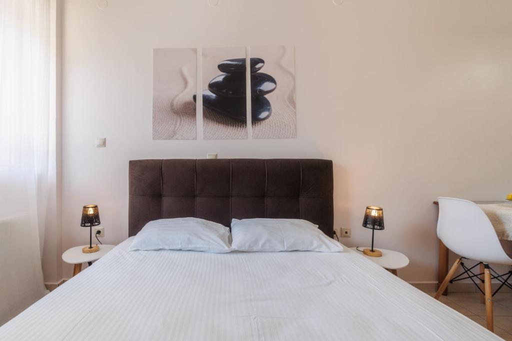 a bedroom with a large bed with two lamps at Paralia Vergas Apartments Studio in Verga Kalamata