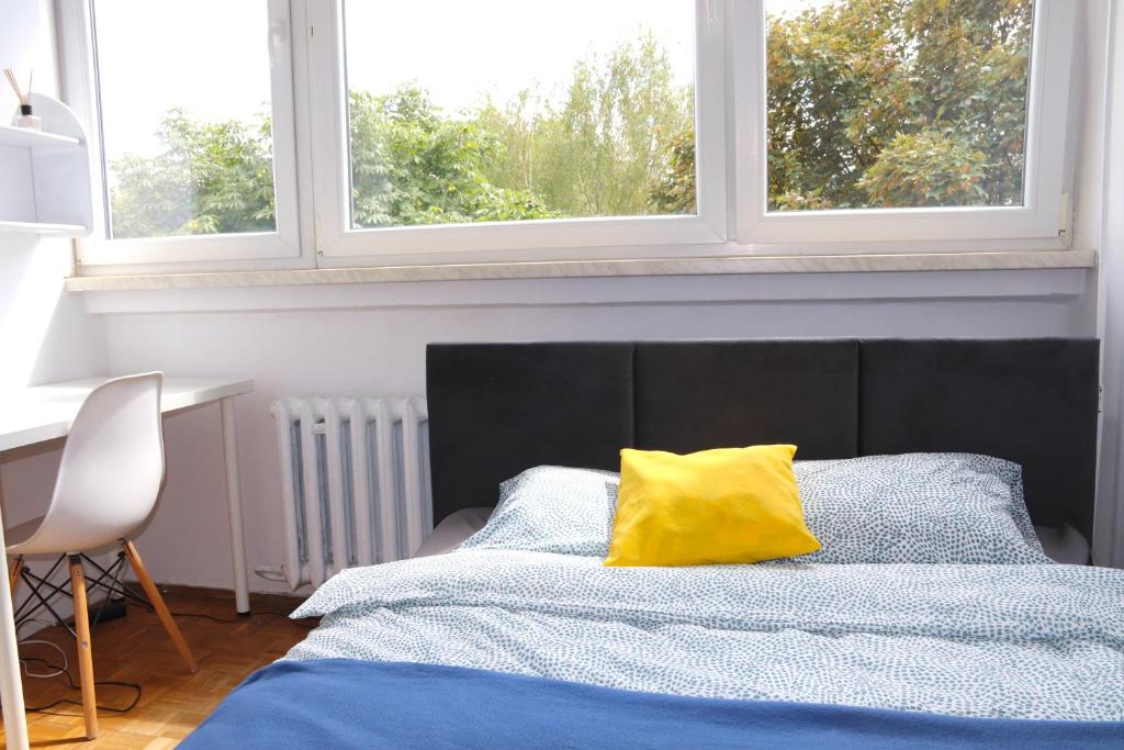 a bedroom with a bed with a yellow pillow on it at Noclegi - ul Czarnieckiego in Wrocław