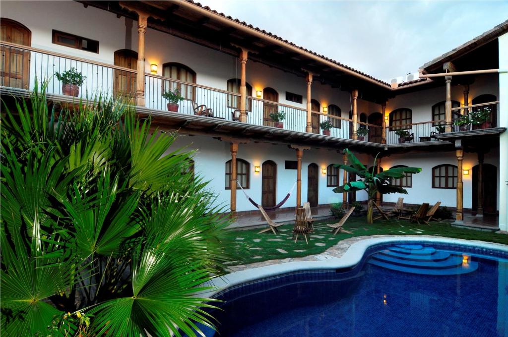 um hotel com piscina em frente a um edifício em Hotel Patio del Malinche em Granada