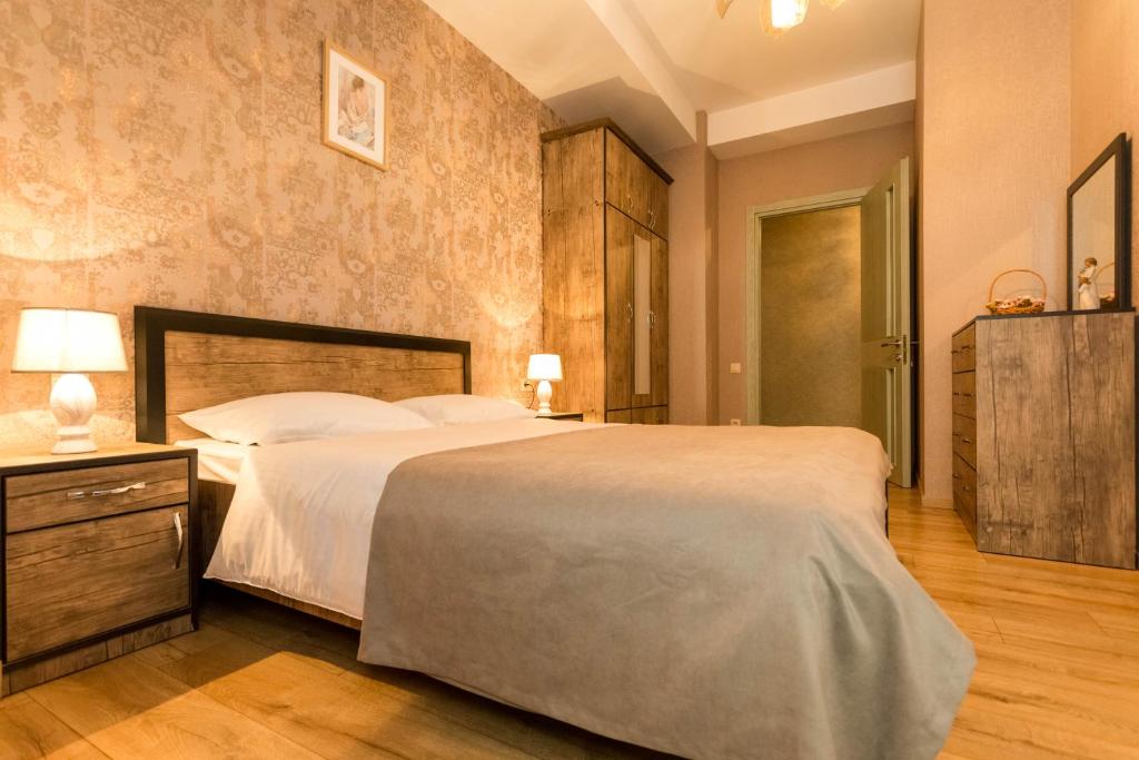 - une chambre avec un grand lit et du parquet dans l'établissement Comfy Home ll, à Tbilissi