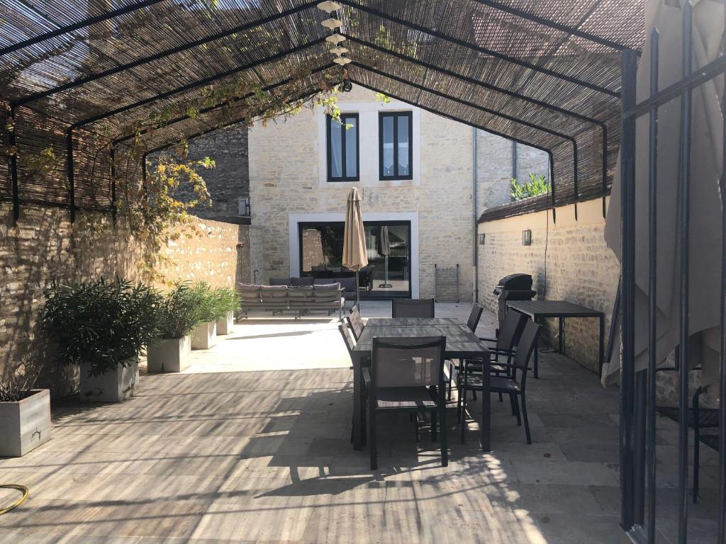an outdoor patio with a table and chairs at Maison de Pauline, Chablis Vineyard in Préhy
