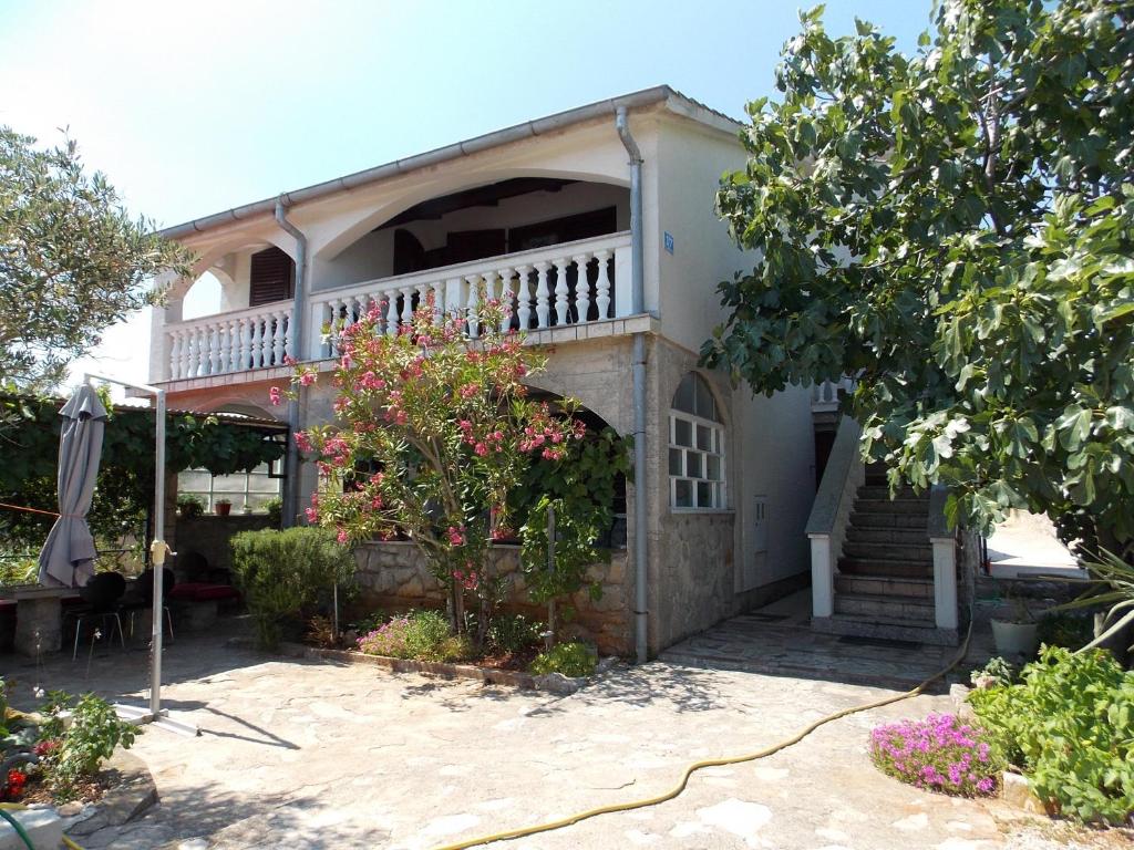a house with a balcony and a patio at Apartments Miro Kornić in Kornić