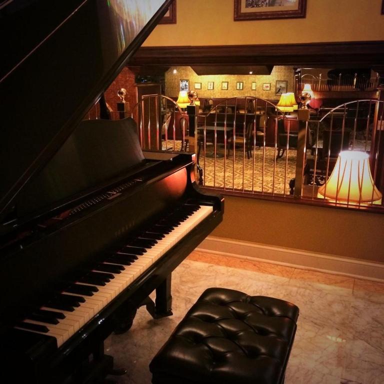 a piano sitting in a room with a lamp at The Claridge Hotel in Atlantic City