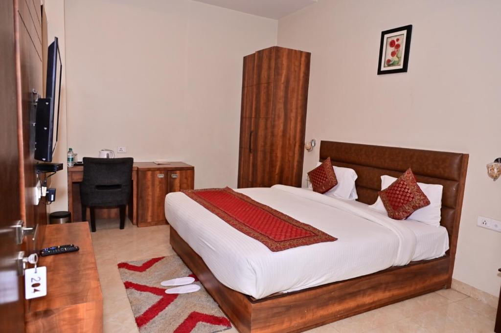 een slaapkamer met een groot bed en een bureau bij Hotel Radiance Courtyard in Varanasi