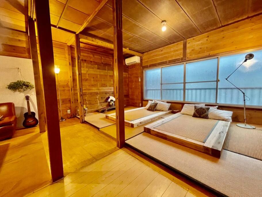 a large room with a bed and a large window at 三丁庵Villa 水質AAの海まで歩いて10分 観光地ペリーロードまで徒歩2分の最高なロケーション 下田をを遊び尽くせる貸別荘 2min walk to the Perry Road 10min walk to the beach Old Japanese modern style house in Shimoda