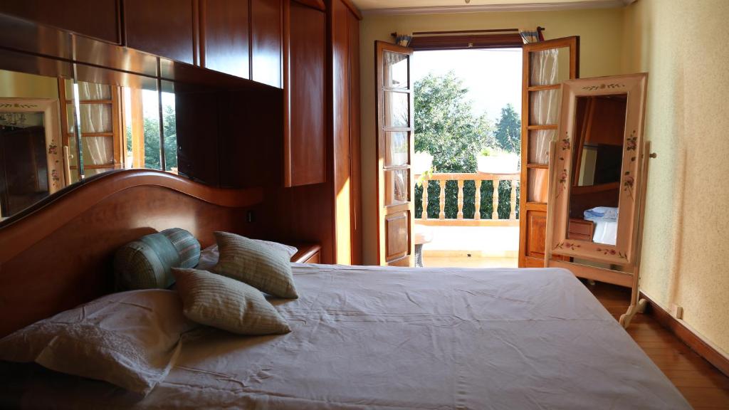 een slaapkamer met een groot bed en een groot raam bij Habitaciones Dobles en Casa in Villanueva