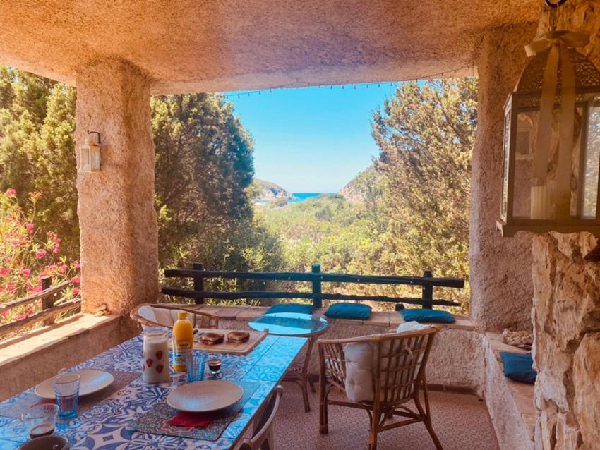 una mesa y sillas en un balcón con vistas en Villa sul Mare Calalunga Calasetta Sant Antioco, en Calasetta