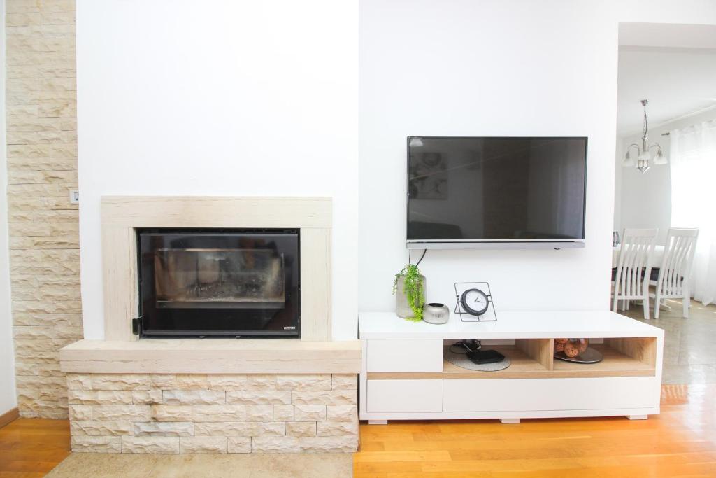 sala de estar con chimenea y TV en Apartments Lotta, en Zadar