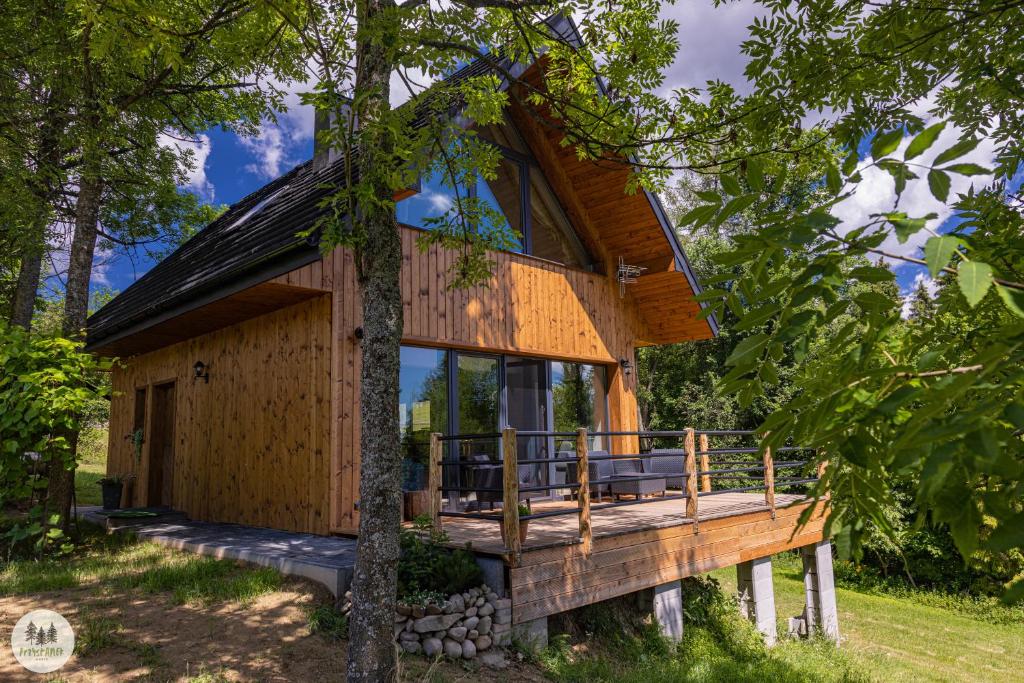 a tree house in the woods with a wrap around deck at Przystanek Gorce in Nowy Targ