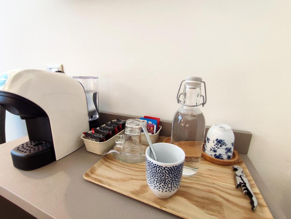 ein Schneidebrett mit Kaffeemaschine und eine Tasse auf der Theke in der Unterkunft Le stanze di Diana in Cesenatico