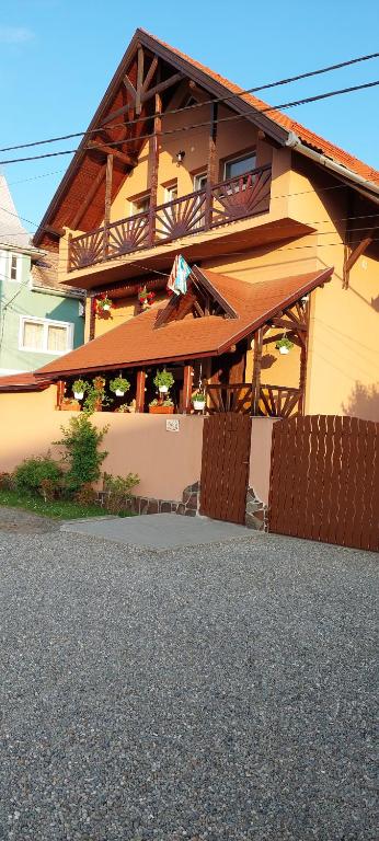 una casa con un balcón en el lateral. en Lörincz Vendégház, en Corund