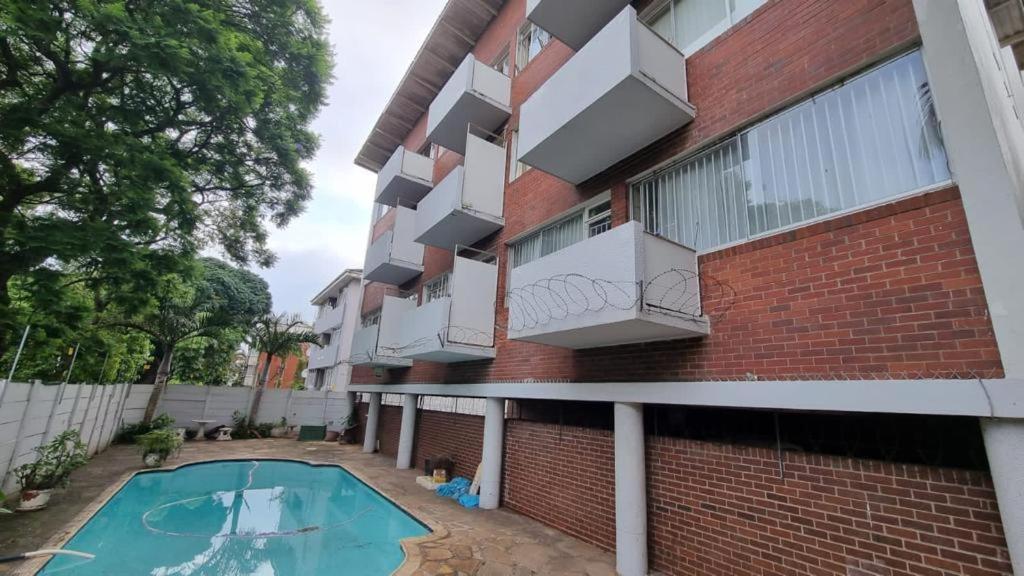 ein Mehrfamilienhaus mit einem Swimmingpool davor in der Unterkunft Everly4 Guest Apartment in Durban