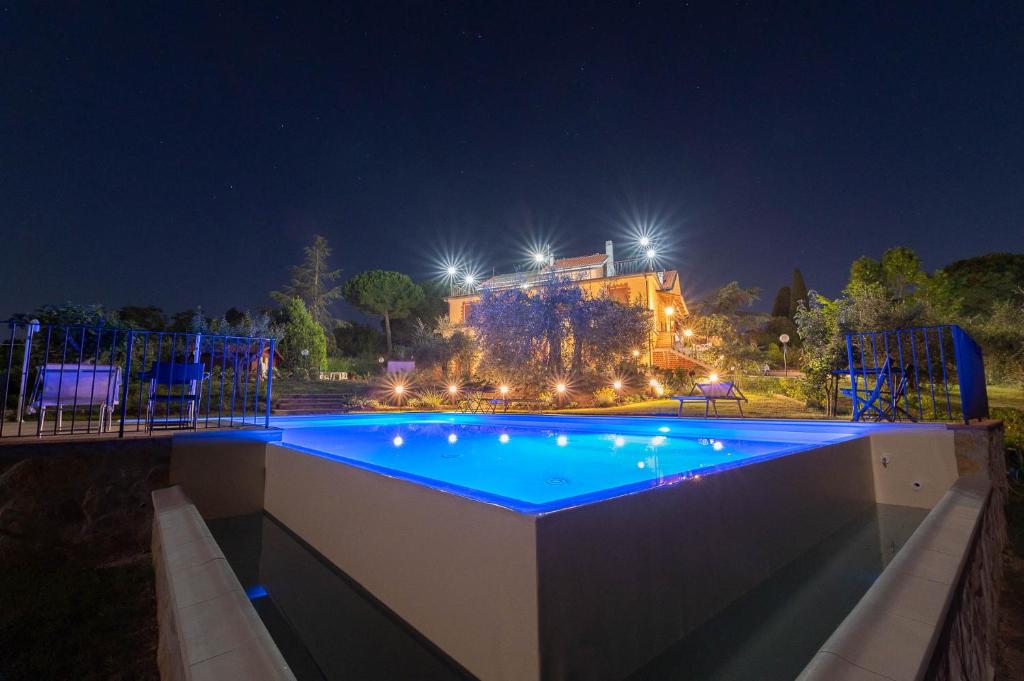 ein großer Swimmingpool in der Nacht mit Lichtern in der Unterkunft Poggio delle Rose Tuscany Relais in Chianciano Terme