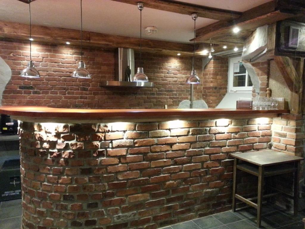 a brick wall with a bar with a stool at Hostel BAZA 15 in Wrocław