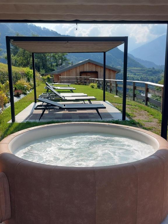 bañera de hidromasaje con vistas a una casa en Maso al Sole Agriturismo en Civezzano