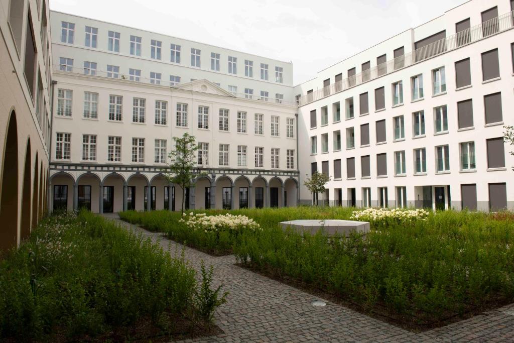 a row of buildings with a courtyard with flowers at CityAntwerp een Oase van rust direct achter de Meir in Antwerp