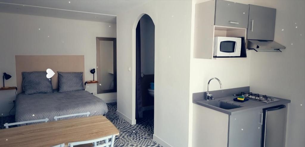 a small room with a bed and a sink at Studio aux portes d' Amiens in Cagny
