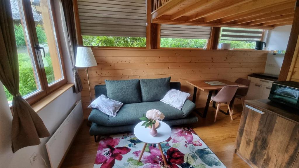 ein kleines Wohnzimmer mit einem Sofa und einem Tisch in der Unterkunft Grajski oddih in Cerklje na Gorenjskem