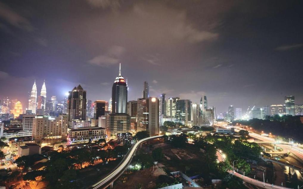 uma cidade iluminada à noite com trânsito em Regalia Residence KLCC View by iLuxHome em Kuala Lumpur