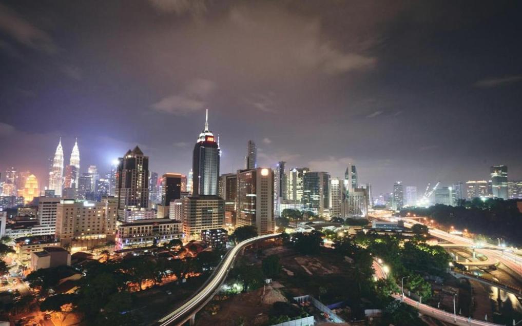 a city lit up at night with traffic at Regalia Residence KLCC View by iLuxHome in Kuala Lumpur