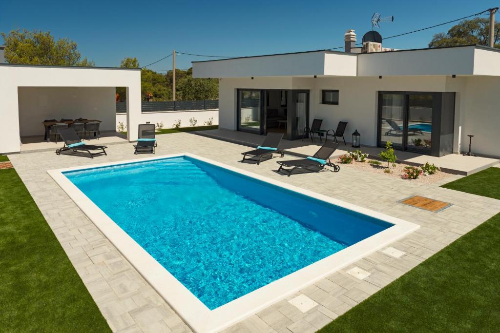 a swimming pool in the backyard of a house at Villa Abelia in Pirovac