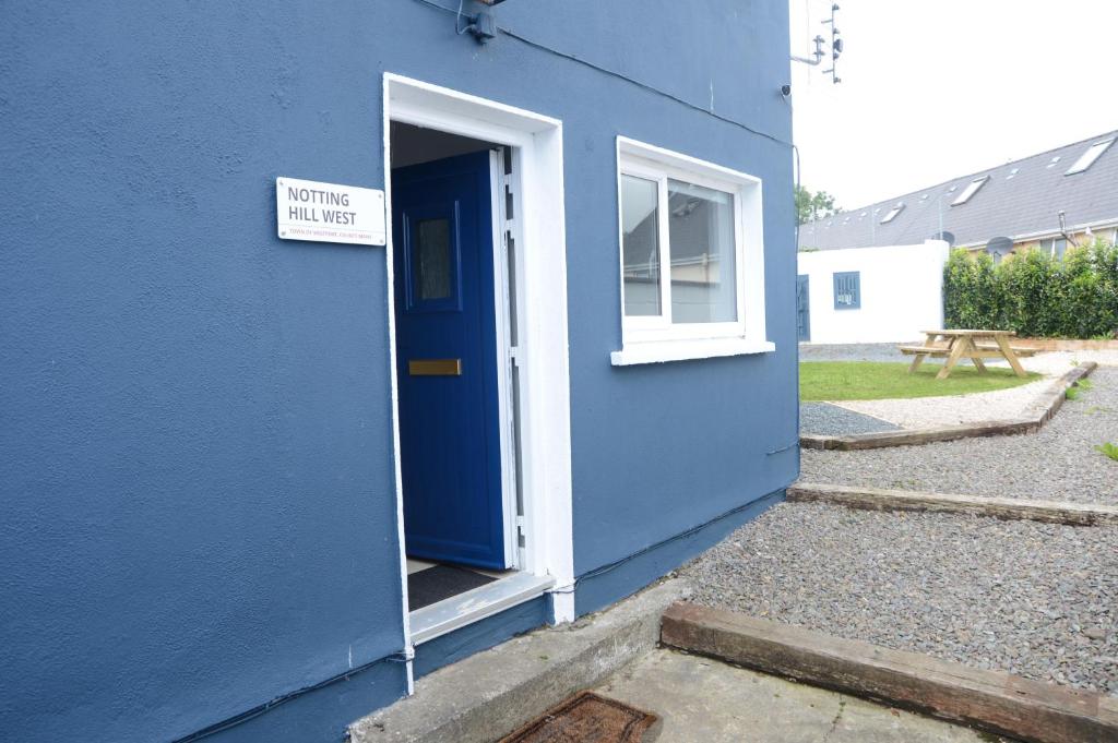 a blue building with a blue door and a sign at Notting Hill West in the heart of Westport Town in Westport