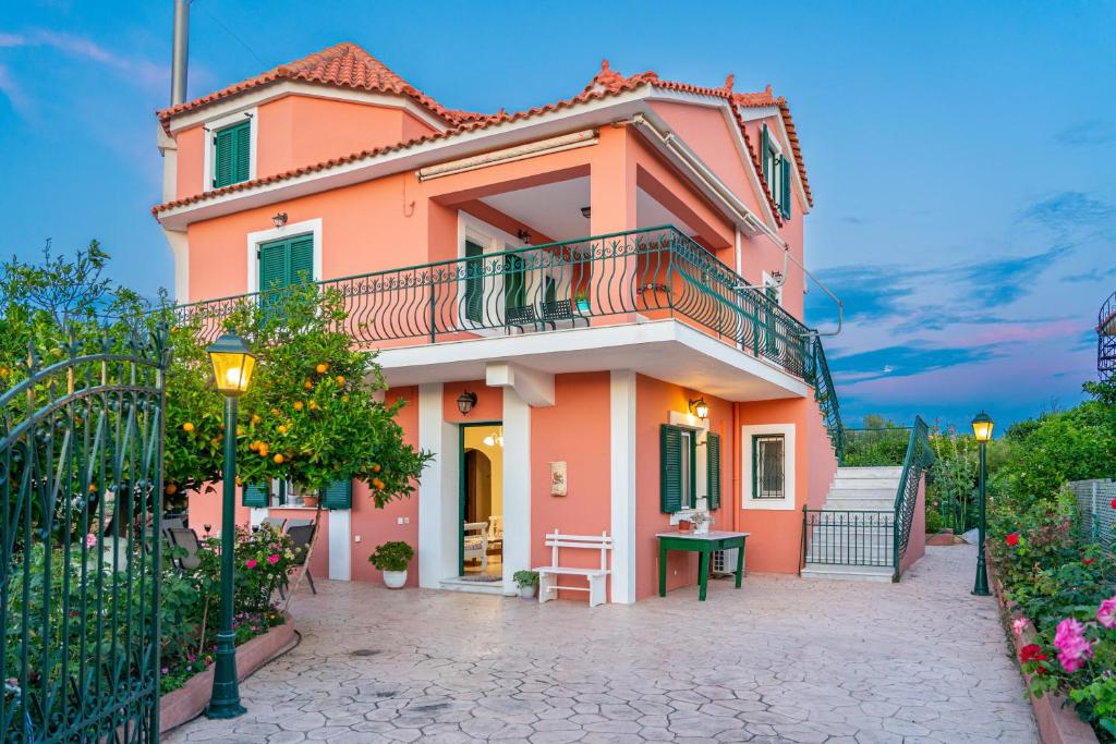 a pink house with a balcony on a street at Artemis superb 2 bedroom apartment 700 m away from the beach in Minia