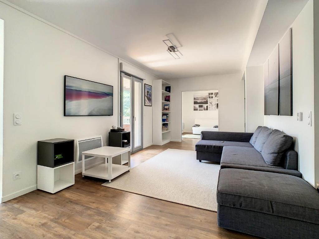 a living room with a couch and a tv at Superbe appartement entièrement rénové au pied des montagnes avec parking inclus in Bagnères-de-Bigorre