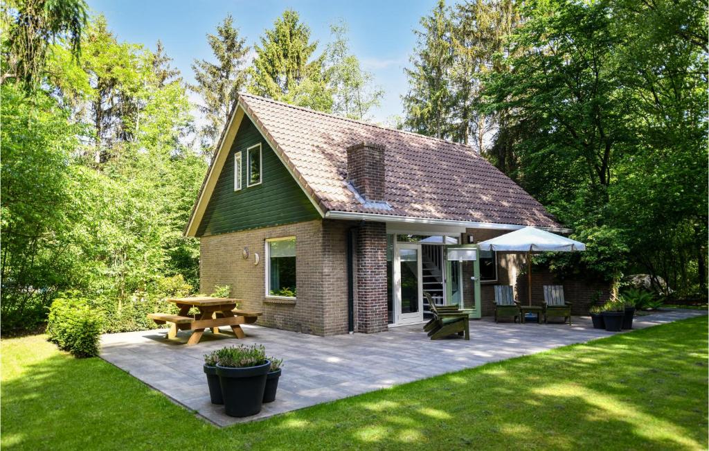 een klein huis met een patio en een picknicktafel bij Awesome Home In Meppen With Kitchen in Meppen