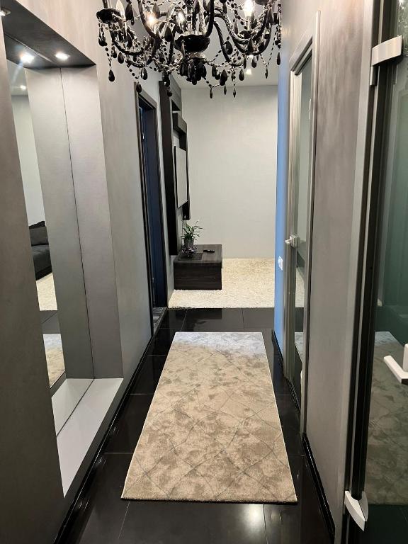 a hallway with a chandelier and a hallway with mirrors at EVIS LTD apartments 2 in Rēzekne
