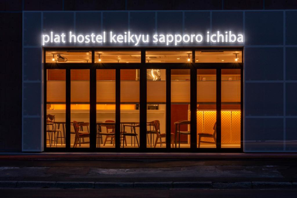 una ventana de un restaurante con sillas. en plat hostel keikyu sapporo ichiba en Sapporo