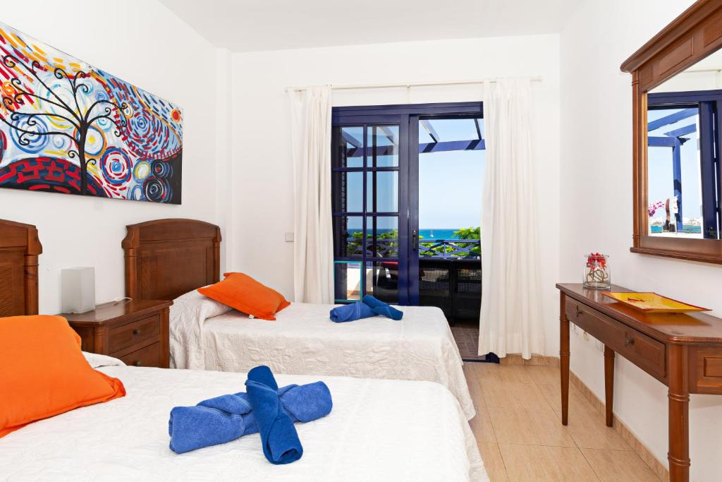 sypialnia z 2 łóżkami i oknem z widokiem na ocean w obiekcie Dorada Center Close to the Beach Playa Blanca By PVL w mieście Playa Blanca
