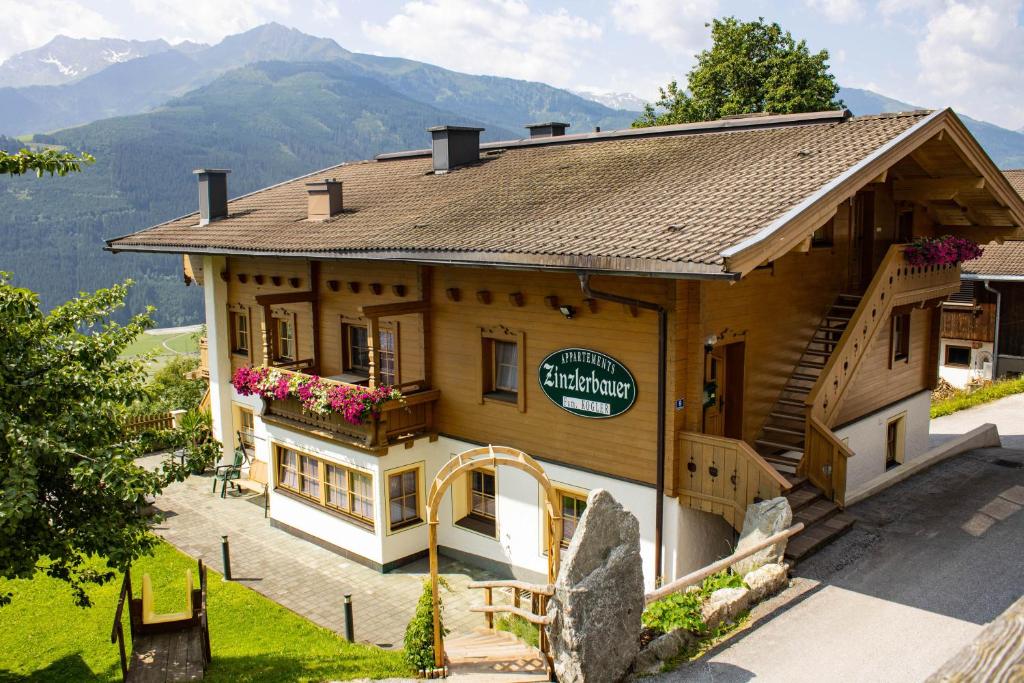 un gran edificio de madera con un cartel. en Ferienwohnungen Zinzlerbauer, en Uttendorf