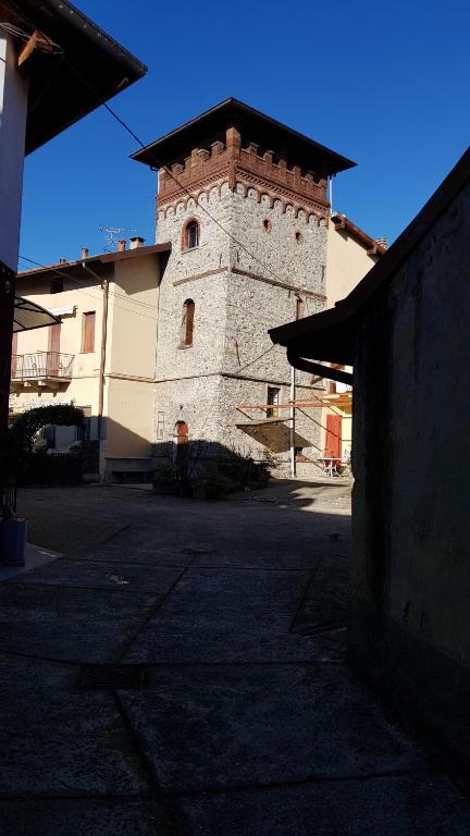 a tall building with a clock tower in front of a building at IL TORRINO in Golasecca