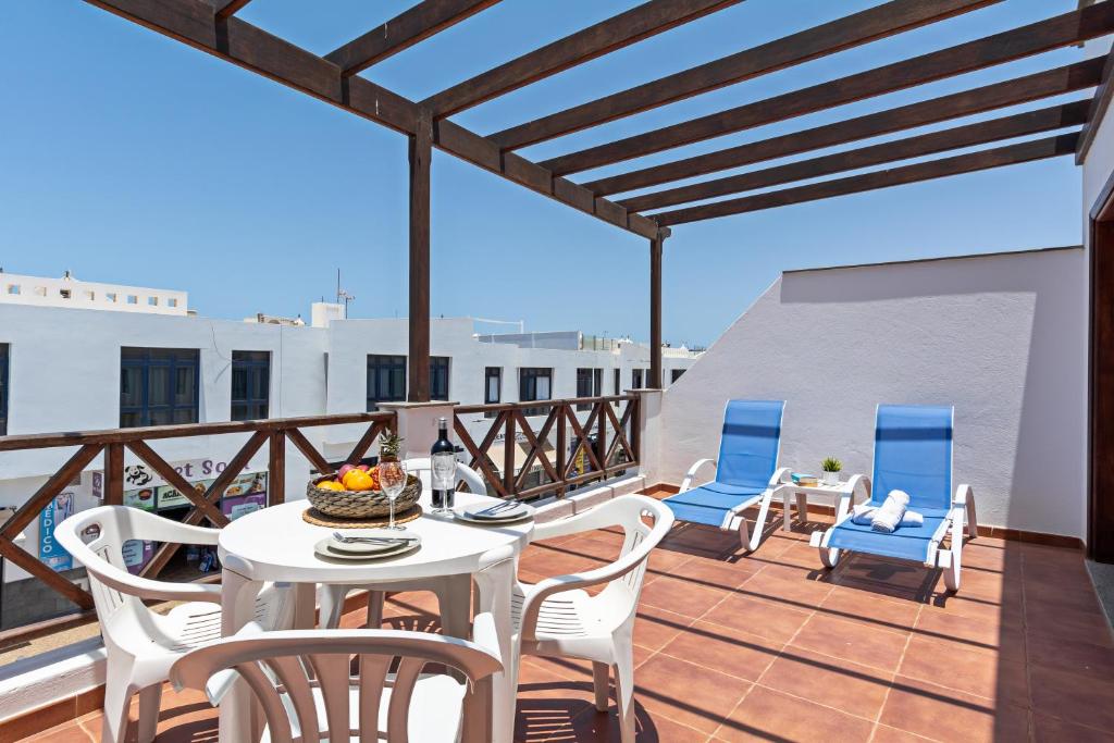 a patio with a table and chairs on a balcony at Apartment Lima Prime Location Playa Blanca By PVL in Playa Blanca