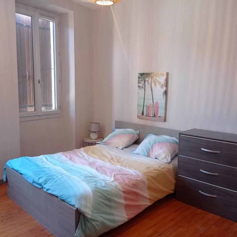 - une chambre avec un lit, une commode et une fenêtre dans l'établissement Agréable maison de village à coté de la DOLCE VIA, à Saint-Sauveur-de-Montagut