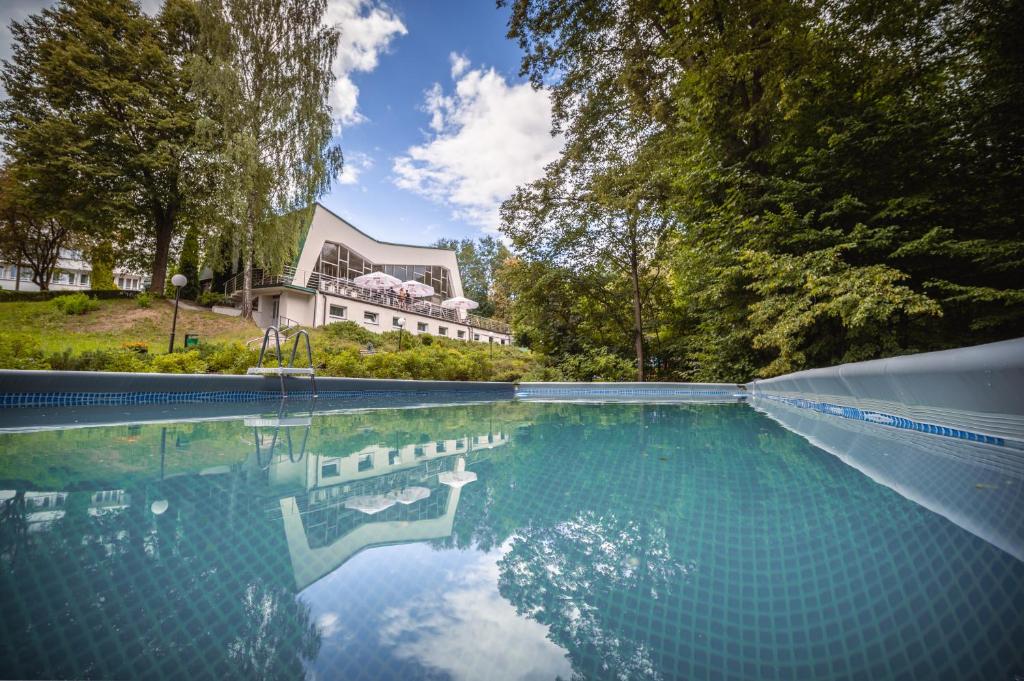 a large swimming pool in front of a house at Hotel Ameliówka in Masłów