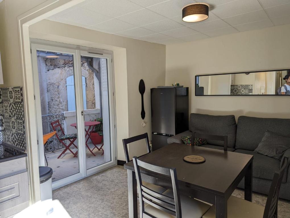 een woonkamer met een tafel en een bank bij Agréable maison de village à coté de la DOLCE VIA in Saint-Sauveur-de-Montagut