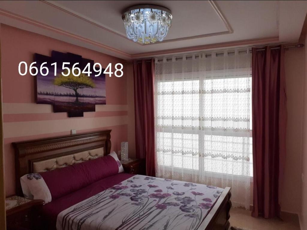 Schlafzimmer mit einem Bett und einem Kronleuchter in der Unterkunft Apartment Nador Rif in Nador