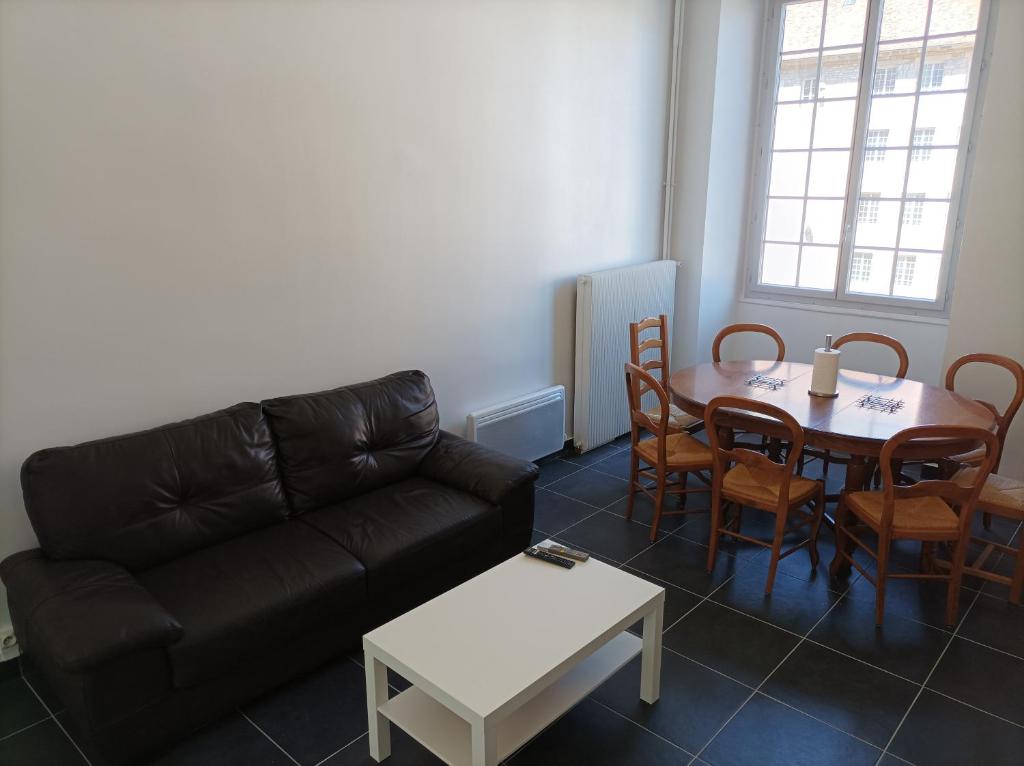 ein Wohnzimmer mit einem Sofa und einem Tisch in der Unterkunft O'Couvent - Appartement 97 m2 - 4 chambres - A514 in Salins-les-Bains