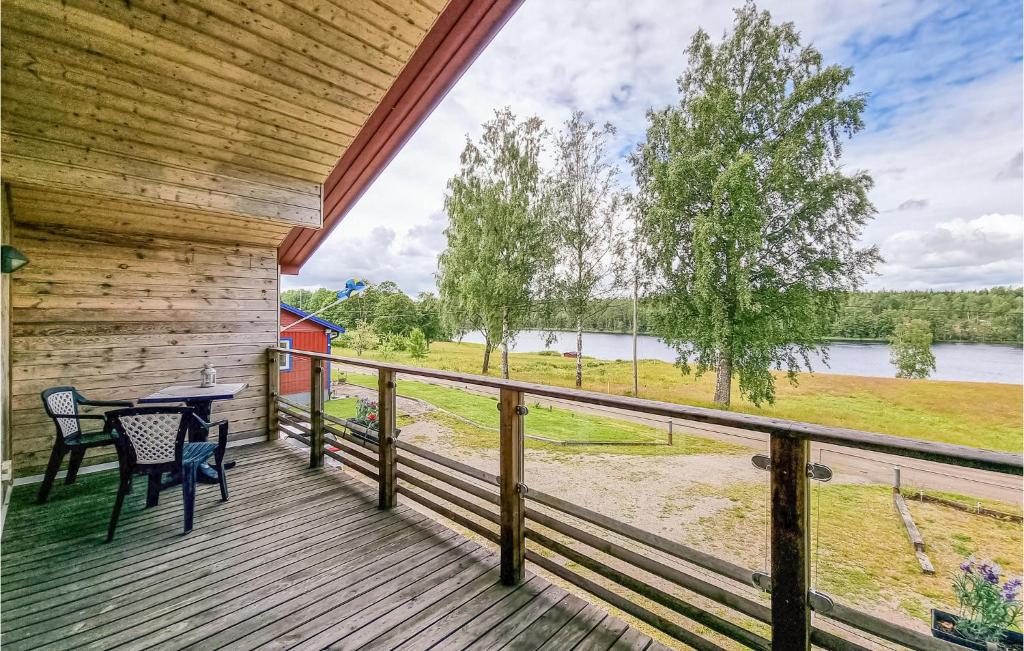 a porch with a table and chairs and a view of a lake at Amazing Apartment In Frgelanda With Kitchen in Färgelanda