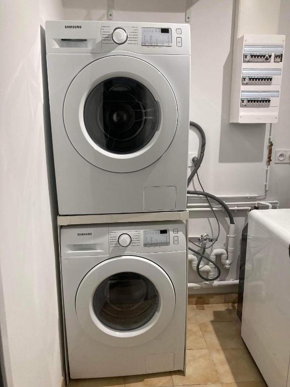 a washing machine and a dryer in a room at Le Cosy Agen-Proche Gare-Salle de sport-Vidéoprojection in Agen