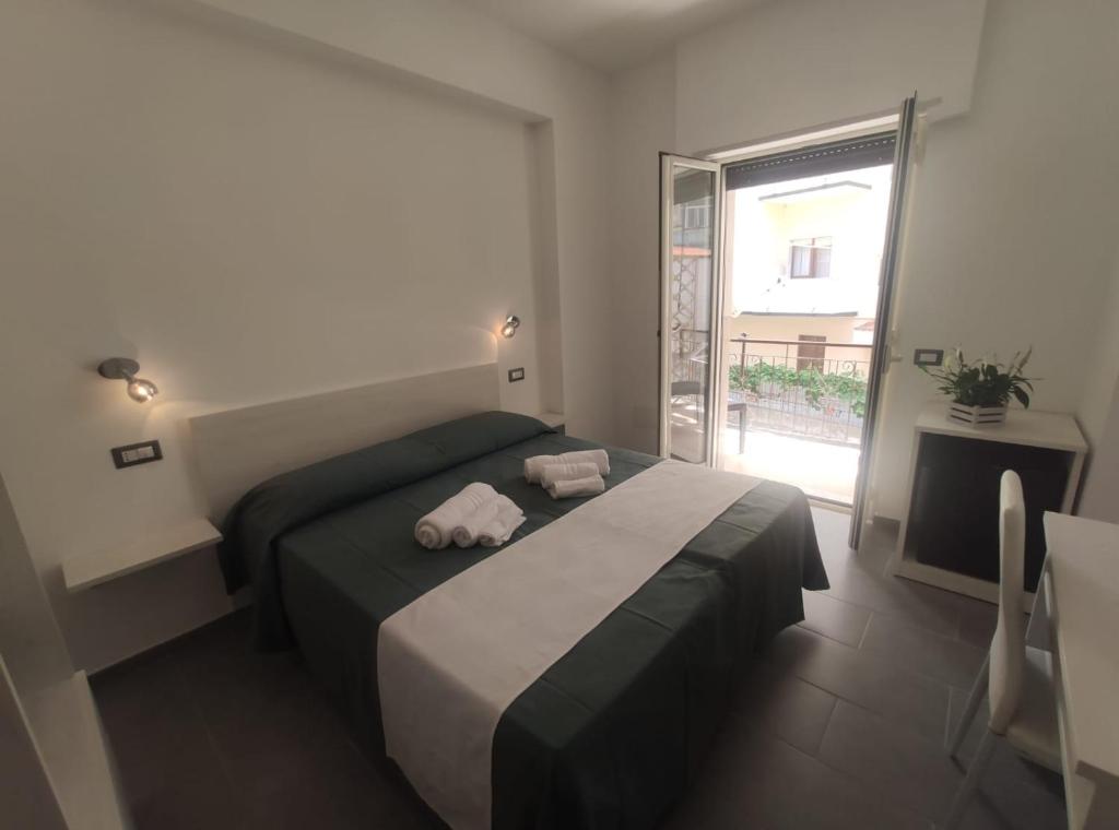 sypialnia z łóżkiem z dwoma ręcznikami w obiekcie Ninfea Tropea City Rooms w Tropei